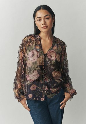 Durchsichtige schwarze Bluse mit floralem Muster aus rosa und grünen Rosen. Rüschenausschnitt und -ärmel, Knopfverschluss, lässige Passform.