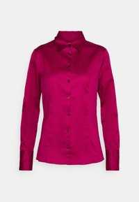 Blouse ajustée en satin magenta à manches longues, avec boutons sur le devant et col pointu, présentée sur un fond clair uni.