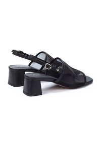 Sandalias de tacón negras con parte superior de malla y punta abierta. Presentan un tacón bloque y una correa ajustable trasera con un hebilla de metal.