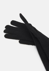 Schwarze gestrickte Handschuhe mit strukturiertem Finish, geripptem Design und langen Fingern, die vollständigen Handschutz und Wärme bieten.