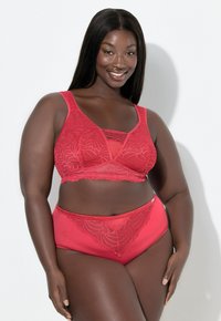 Punainen pitsirintaliivit ja niihin sopivat korkeavyötäröiset alushousut, joissa on monimutkaiset kukkakuviot ja sileä satiinipinta. Säädettävät olkaimet mukana.