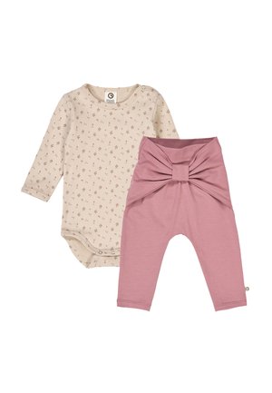 Pitkähiha bodysuit vaaleassa sävyssä, jossa on kukkakuosi, yhdistettyinä vaaleanpunaisiin leggings-housuihin, joissa on etuosan solmuvetoketju ja pehmeä kangas.