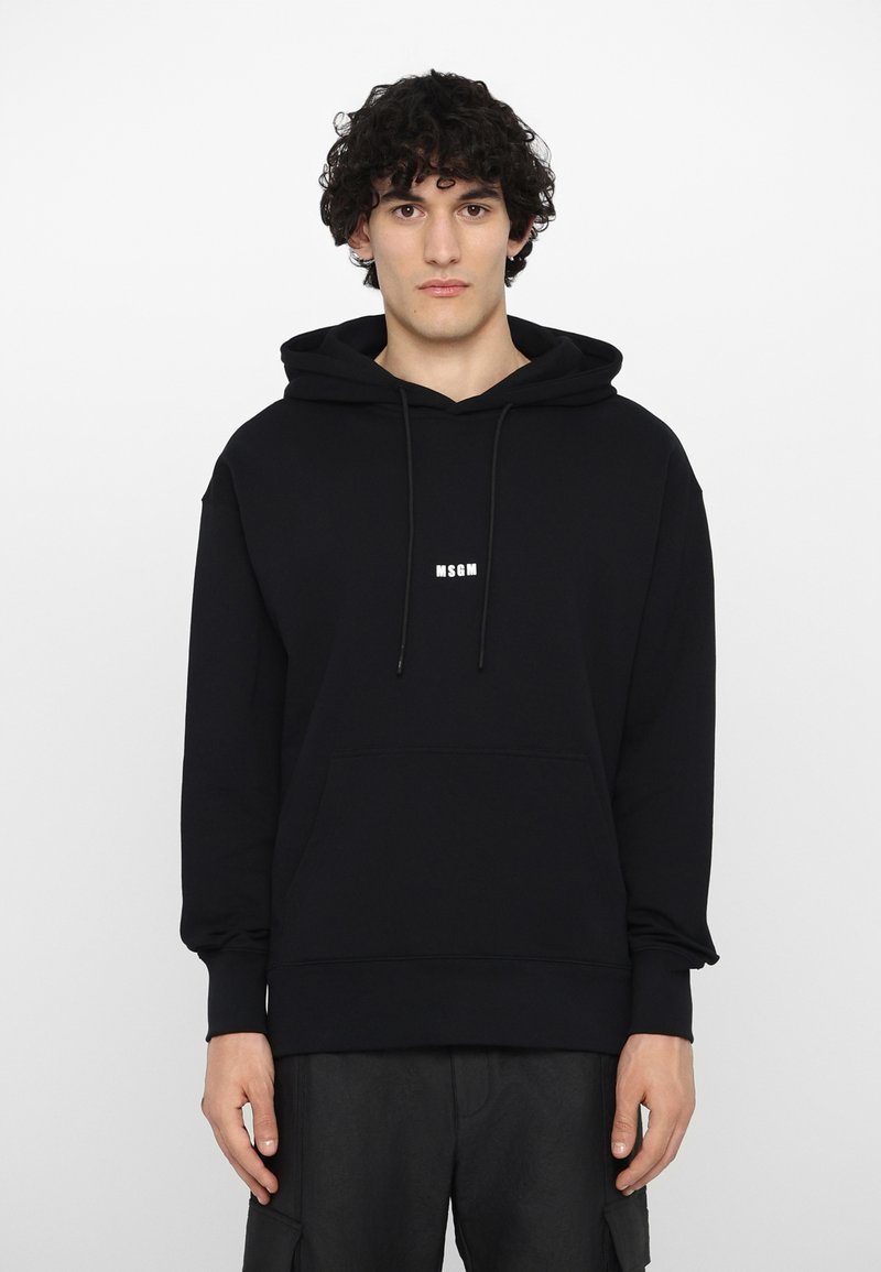Felpa nera con cappuccio e tasca frontale, caratterizzata da un piccolo logo bianco "MSGM" sul petto. Realizzata in un morbido tessuto texturizzato.