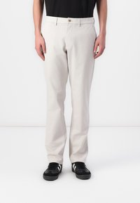 Pantalon beige clair en coton mélangé, avec une coupe droite, des poches avant et une fermeture à un bouton.