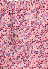 Floral fabric with a gathered ruffle edge. Features small, multicolored flowers in shades of pink, red, and purple on a cream background.
