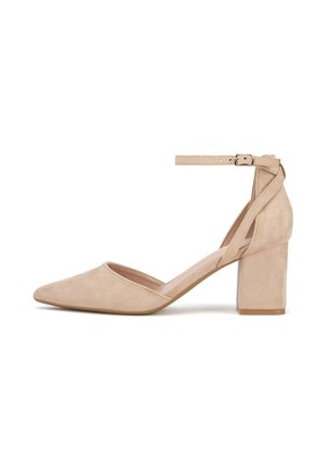 Beżowy zamszowy but na wysokim obcasie z ostrym noskiem i szerokim, blokowym obcasem. Posiada pasek wokół kostki zapinany na srebrną klamrę.