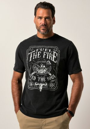 Schwarzes Baumwoll-T-Shirt mit einem Grafikdruck, der den Text "Fuel The Fire" sowie Illustrationen von Kochwerkzeugen und einem Totenkopf zeigt. Kurze Ärmel und Rundhalsausschnitt.