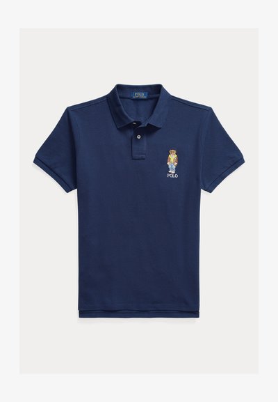 Polo bleu marine en coton, avec une patte de boutonnage à trois boutons et un logo d'ours brodé sur la poitrine gauche. Manches courtes avec une coupe classique.