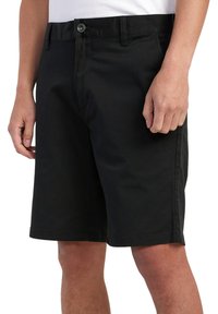 Shorts de algodón negros con cierre de botón, trabillas para cinturón y bolsillos laterales. Corte recto con una textura suave y bordes rematados.