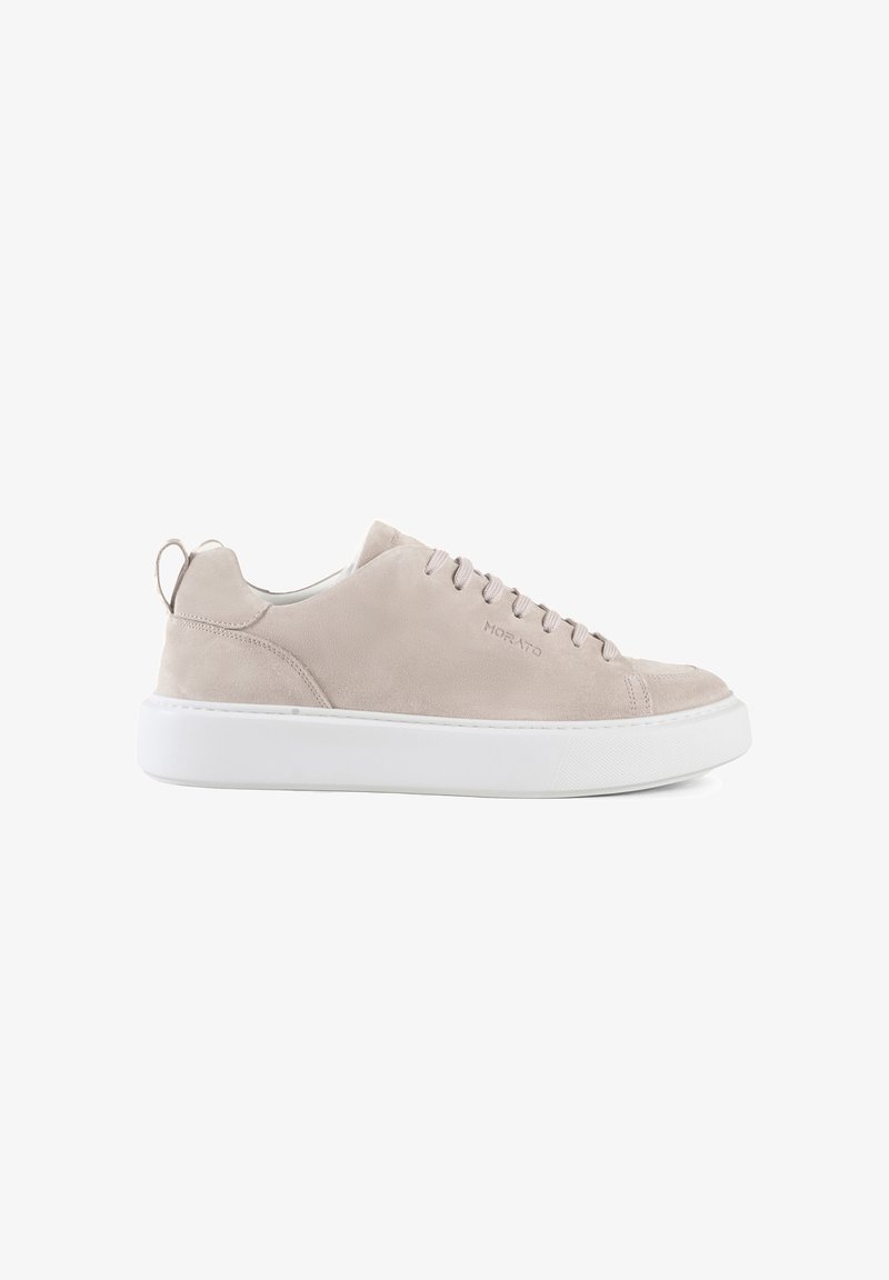 Beige suede sneakers with white rubber sole, rounded toe, and lace-up design. Features a back pull tab and embossed logo detail.