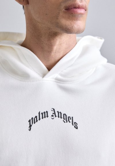 Weißer Hoodie mit einem schwarzen "Palm Angels"-Logo, das in einem Bogen aufgedruckt ist. Das Material scheint weich und strukturiert zu sein und hat eine lockere Passform.