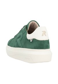 Green suede sneaker with white heel, textured surface, flat sole, and reinforced stitching. Features branding detail on the heel tab.