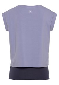 Lockere T-Shirt mit Kapuzenärmel, in der Hauptfarbe Lavendel und einer navyfarbenen unteren Schicht. Logo am Rückenkragen aufgedruckt.