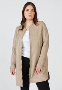 Beige läderjacka med dragkedja framtill, rund halsringning, långa ärmar och sidofickor; slät textur med minimal hårdvara.
