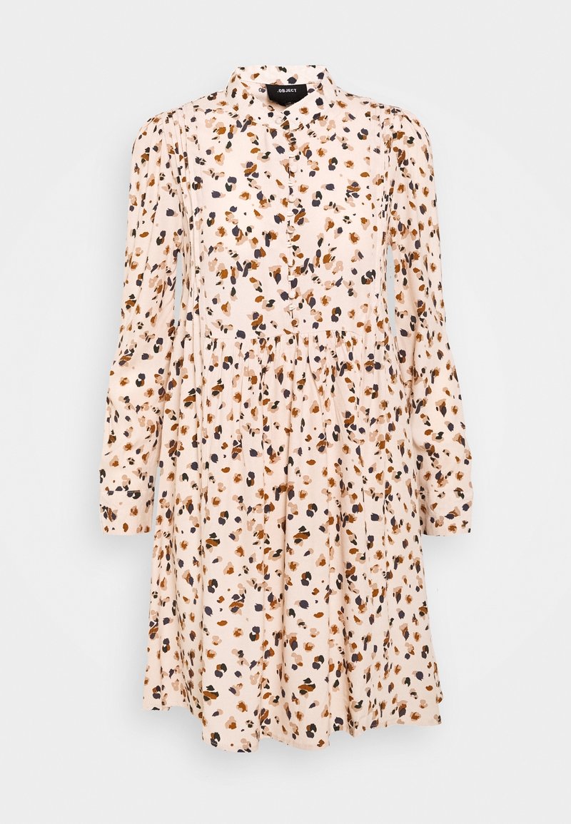 Robe rose clair à manches longues avec col, boutonnée sur le devant, taille froncée et motif abstrait de taches marron, noir et orange.