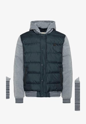 Polstret jakke med en svart quiltet kropp, grå hettegenserermer og stripete ribbede mansjetter. Har hette og knappelukking foran.