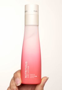Flaska med rosa ombre-lotion med frostad finish, rund bas och vit kork. Etiketten säger "NUTRITIOUS AIRY LOTION" med detaljer nedanför.