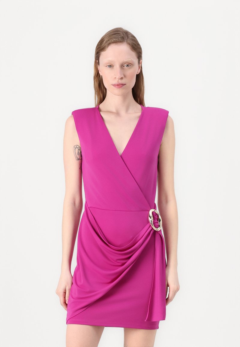 Vestido fúcsia com decote em V, sem mangas, com textura drapeada e um detalhe de fivela lateral. Tecido suave com silhueta ajustada.