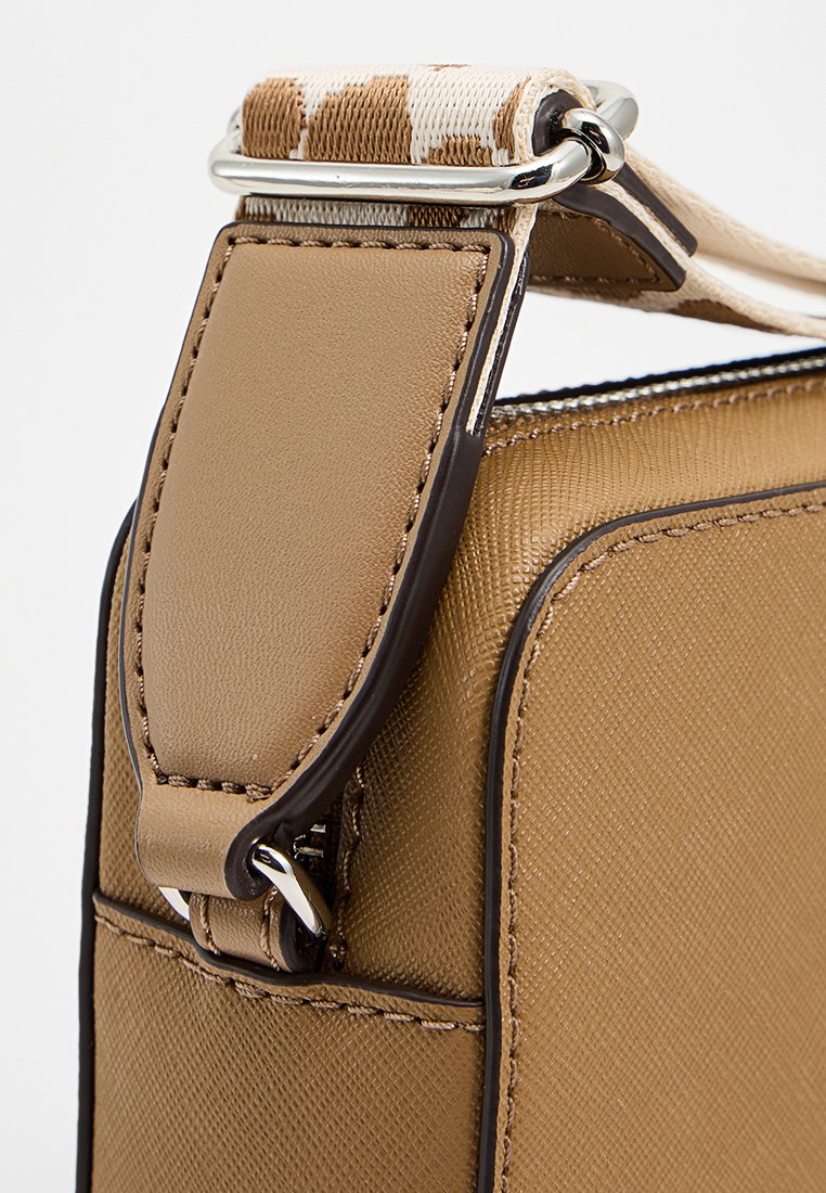 Sac à main en cuir marron avec une finition texturée. Doté d'une bandoulière beige contrastante avec une bordure à motifs et de quincaillerie en argent pour l'attache.