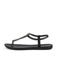 Black flat sandal with a braided strap design and a textured sole. Features a toe post and an adjustable ankle strap. Sleek and minimalist style.