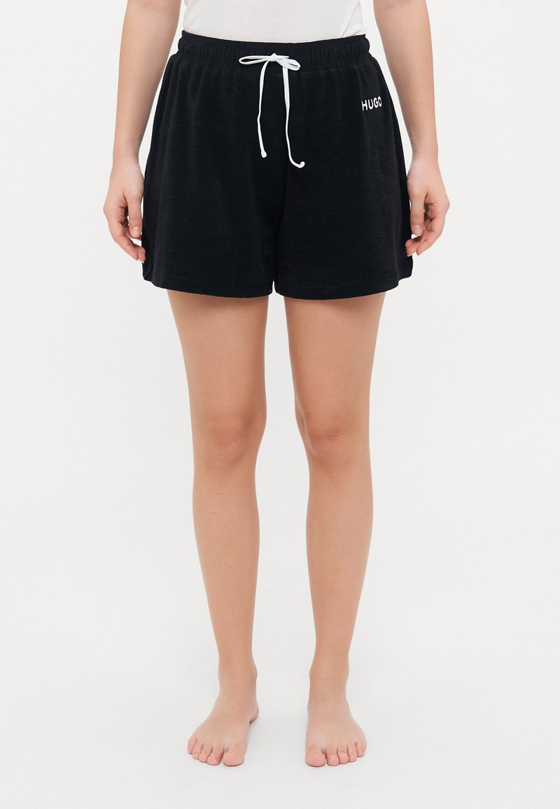 Svarta shorts av mjukt tyg, med resårmidja och vit dragsko samt vit logodetalj på sidan.
