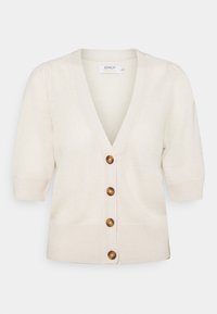 Krämfärgad stickad cardigan med V-ringning, korta puffärmar och fyra bruna knappar framtill. Strukturerad tyg med ribbade ärmslut.