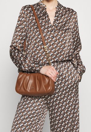 Sac d'épaule en cuir marron avec un design texturé et froncé. Il est doté d'une bandoulière en chaîne dorée et d'un détail de logo discret sur le devant.