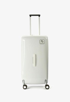 Valigia rigida bianca con manico telescopico, quattro ruote, design a strisce verticali e un logo su un angolo.