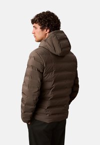 Chaqueta acolchada aislante marrón con capucha desmontable, diseño de acolchado horizontal y textura suave. Presenta una silueta ajustada y puños elásticos.