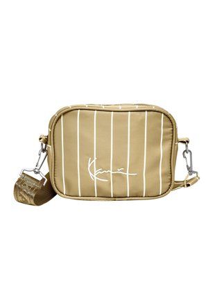 Petit sac bandoulière beige avec des rayures blanches verticales, signature blanche sur le devant, et sangle réglable amovible avec clips métalliques.