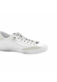 Scarpa sportiva bianca con design perforato, dettagli grigio chiaro e lacci piatti. Suola in gomma con leggeri segni di usura visibili sul fondo.