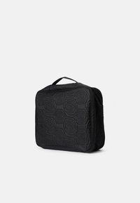 Sac noir matelassé avec un motif de roses, de forme rectangulaire, doté d'une poignée supérieure et d'une fermeture éclair. Texture douce avec des détails de couture contrastés.