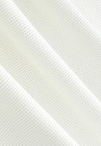 Fehér, texturált szövet, négyzetrácsos mintával, kiemelkedő négyzetekkel a sima felületen, tapintási és vizuális kontrasztot teremtve.