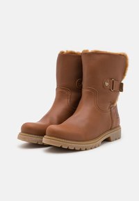 Braune Leder-Ankle-Boots mit strukturierter Oberfläche, ausgestattet mit einem Kunstfellfutter oben, seitlicher Schnallenhardware und Gummisohle.