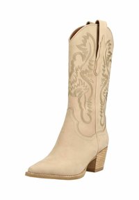 Bota de vaquero de cuero beige con patrones florales bordados y un tacón de madera apilada, con tiradores en la parte superior.
