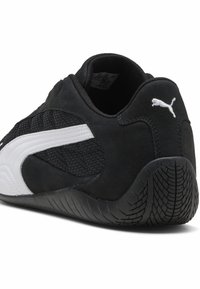 Must must sportlik kingad, millel on tekstuuriga võrgupaneel, valged aktsendid ja kummist tald, millel on mustriga tallani. Puma logo kandadel.