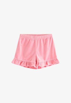 Smilende ung pige med blond hår i to hestehaler iført en pink lynlåshættetrøje, flæse-shorts, skjorte med fugleprint og blomstrede slip-on sko.