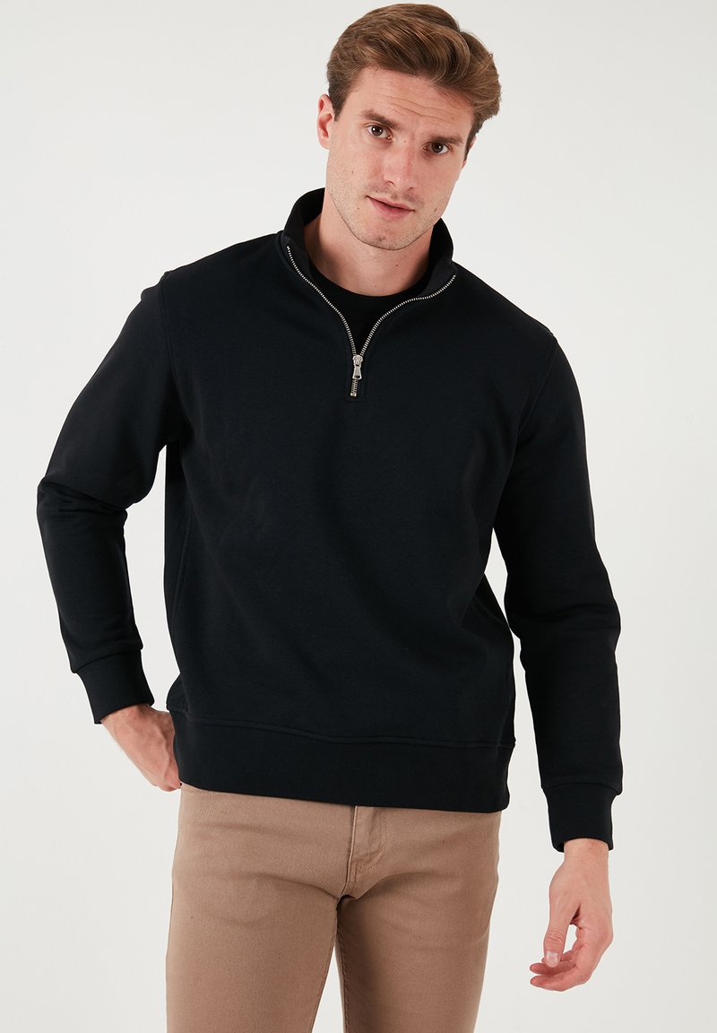 Black zip-up sweatshirt with a high collar, long sleeves, and a relaxed fit. Made from a soft fabric with ribbed cuffs and hem.