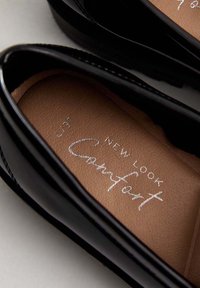 Czarne lakierowane baleriny o gładkiej fakturze i brązowej wkładce. Zawierają wytłoczone srebrne logo "New Look Comfort".