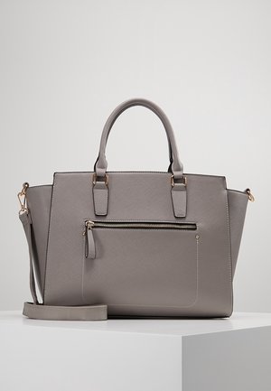 Sac à main en cuir gris texturé avec deux poignées, une poche frontale zippée et une bandoulière amovible sur une surface blanche.