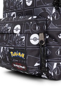 Black fabric backpack featuring white Pokémon graphics, a front pocket with zipper, and colorful Pokémon and Eastpak logos. Textured surface.