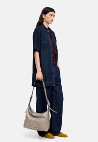 Czarna dżinsowa oversize'owa koszula i spodnie, bordowy top, szara torba na ramię z regulowanymi paskami oraz musztardowe buty. Gładka tekstura i casualowy design.