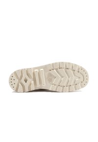 Semelle de chaussure en matériau en caoutchouc beige clair texturé, présentant un motif en zigzag et un motif circulaire pour une adhérence améliorée.