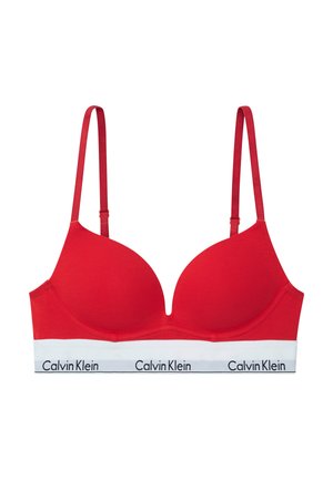Piros melltartó puha párnázással, állítható pántokkal és fehér szalaggal, amelyen fekete betűkkel szerepel a "Calvin Klein" felirat. Sima szövet tapintása.