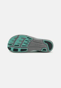 Suola di una scarpa caratterizzata da due colori: grigio e teal. Gomma testurizzata con motivi e scanalature variabili per aderenza e flessibilità.