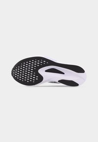 Σόλα παπουτσιού με μαύρο και λευκό λαστιχένιο πέλμα, κυκλικό μοτίβο λαβής στο εμπρόσθιο μέρος και λεία υφασμένη τμήματα κοντά στη φτέρνα και την καμάρα.