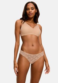 Bardotka w kolorze nude z koronkowymi wykończeniami oraz pasującym koronkowym stringiem. Bardotka ma dekolt w kształcie litery V i miękki materiał. Stringi mają kwiatowy wzór koronki na pasku.
