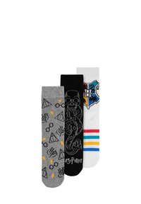 Tre paia di calzini: grigi con occhiali e design di fulmini, neri con un teschio e bianchi con un accento a strisce colorate e uno stemma.