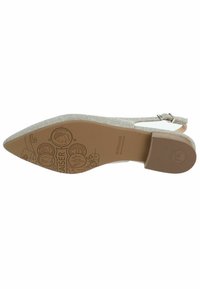 Talons ouverts beiges avec un bout pointu. La partie supérieure présente une finition en tissu texturé, et la semelle arbore un design de marque avec une texture en caoutchouc.