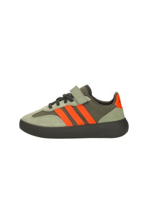 Baskets basses en daim vert olive et beige, bandes orange vif, semelle noire, lacets et une fermeture velcro sur le côté.